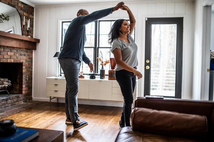 Married-couple-dancing-in-residential-living-room-purpose-of-premarital-counseling